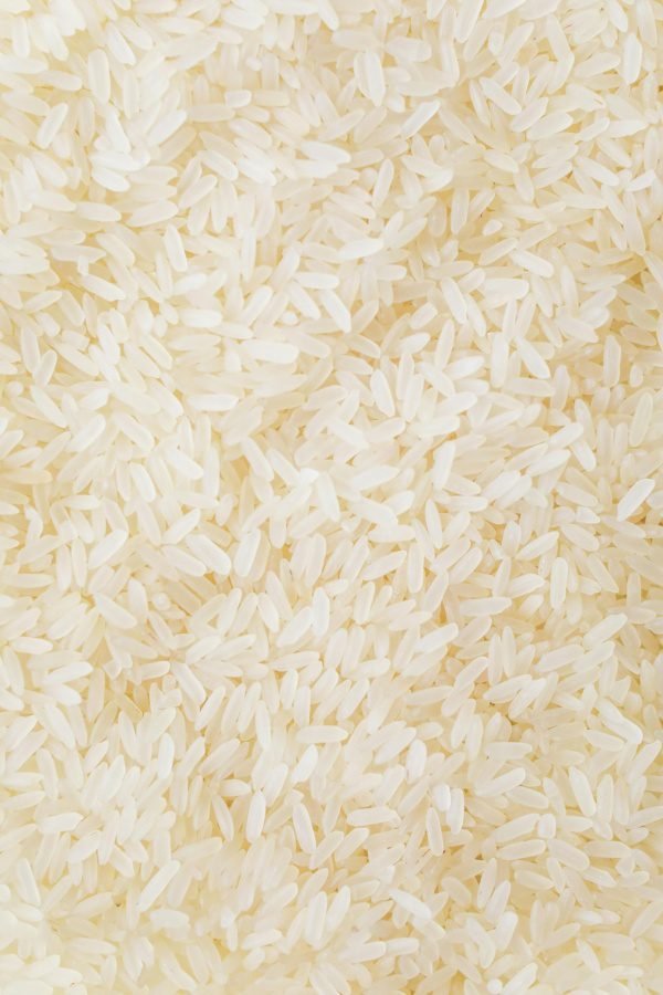 Close-up image of numerous white rice grains, showcasing texture and abundance.